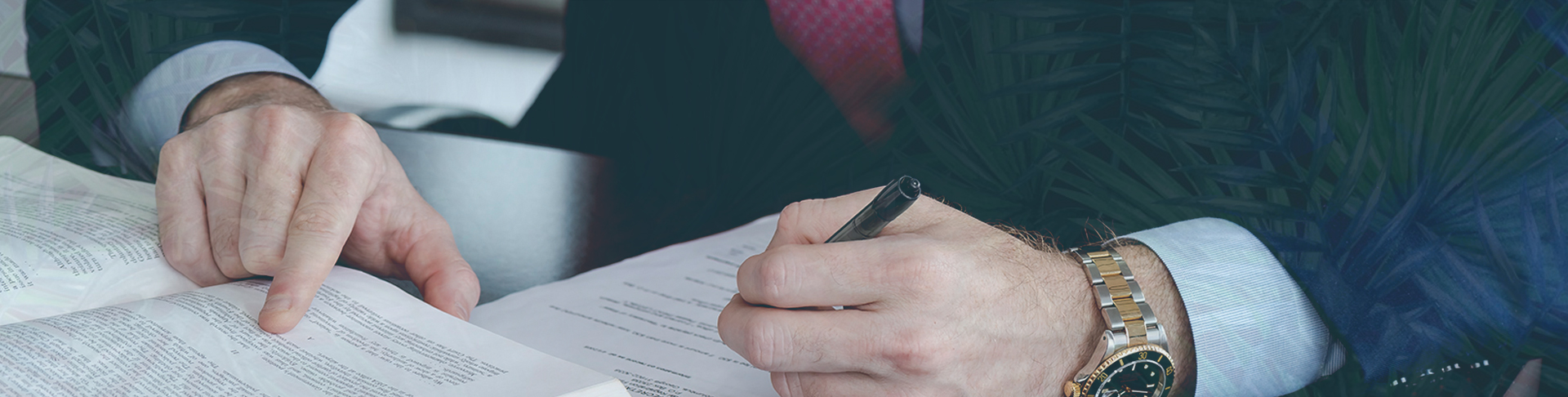 Hands signing contract with pen and watch